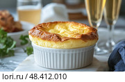 Delicious cheese souffle rising in a ramekin, celebrating with sparkling wine. Стоковое AI-изображение, AI-художник Юрий Поздников / Фотобанк Лори