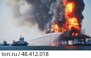 Firefighters extinguishing burning offshore oil rig platform. Стоковое AI-изображение, AI-художник Юрий Поздников / Фотобанк Лори