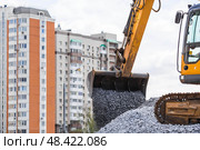 Heavy machinery for construction and landscaping. An excavator on a construction site in close-up. An excavator loads crushed stone into a bucket for construction. Стоковое фото, фотограф Photojuli / Фотобанк Лори
