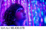 Boy's Wonder: A Child's Fascination with Sparkling Light Curtains. Стоковое AI-изображение, AI-художник Данила Большаков / Фотобанк Лори