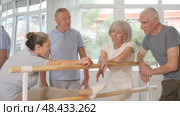 Group of cheerful relaxed aged women and men casually socializing near ballet barre after dance practice in choreography studio. Стоковое видео, видеограф Яков Филимонов / Фотобанк Лори