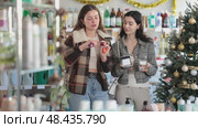Women friends choose cosmetics and nail polish in decorated store. Стоковое видео, видеограф Яков Филимонов / Фотобанк Лори