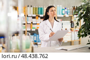 Middle-aged female pharmacist restocking with paper in drugstore. Стоковое фото, фотограф Яков Филимонов / Фотобанк Лори
