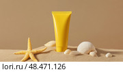 Yellow Sunscreen cream tube, starfishes and seashells on a sand top view. Cosmetic mockup. Sunblock lotion on sandy beach background. Summer vacation care concept, sun screen product, spf uv protect. Стоковое AI-изображение, AI-художник Марина Демидюк / Фотобанк Лори