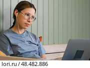 Teen girl school student wear headphones watching online webinar, talking through webcam looking at laptop. Teenager conducting video conference on computer at home, chatting online with friends. 4K. Стоковое фото, фотограф Марина Демидюк / Фотобанк Лори