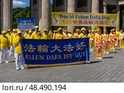 BERLIN - MAY 09, 2025: Participants of World Falun Dafa Day standing with banners at Brandenburg Gate, Pariser Platz, Berlin, Germany. Редакционное фото, фотограф Sergey Kohl / Фотобанк Лори