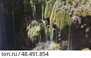 Pristine water cascading over moss-covered stones, forming enchanting waterfall scene nestled in lush turkish landscape. Стоковое видео, видеограф ILIA GOROKHOV / Фотобанк Лори