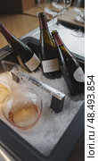 Russia, St.Petersburg, 24 April 2025: Several bottles of champagne brand Bonnet-Ponson are cooled in a niche with ice in the restaurant, local lighting, wine cabinet, decanters for sparkling wine. Редакционное видео, видеограф Vladimir Drozdin / Фотобанк Лори
