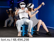 Girls wearing virtual reality glasses play in pairs, against each other, manipulating objects or shooting at targets using joysticks in their hands. Стоковое фото, фотограф Яков Филимонов / Фотобанк Лори