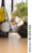 Russia, St.Petersburg, 24 April 2025: bottle of champagne is on table, flowers, wine glass in the restaurant, local lighting, wine cabinet, decanters for sparkling wine. Редакционное видео, видеограф Vladimir Drozdin / Фотобанк Лори