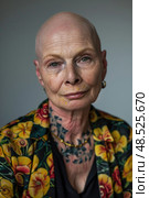 Older bald woman with tattoos on her neck. The tattoos are visible as she stands facing the camera. Стоковое AI-изображение, AI-художник Данила Большаков / Фотобанк Лори