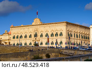 VALLETTA, MALTA - NOVEMBER 12, 2018 - Exterior view of the Auberge de Castille in Castille Square with people walking by. Стоковое фото, фотограф Сергей Богомяко / Фотобанк Лори