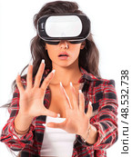 A woman wearing a red and white plaid shirt is wearing a virtual reality headset. Стоковое AI-изображение, AI-художник Ярославский Максим / Фотобанк Лори