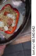 Professional chef preparing stuffed red bell pepper with couscous, feta, cherry tomatoes, roasting seasoned pepper on metal tray in hot oven. Стоковое видео, видеограф Данил Руденко / Фотобанк Лори