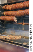 Street food vendor slicing and grilling traditional Turkish kokorec at a local food stall. Стоковое видео, видеограф Дмитрий Наумов / Фотобанк Лори