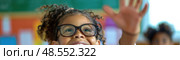 A little girl with glasses is pulling a silly facial expression in this candid shot, showcasing her playful and lighthearted nature. Стоковое AI-изображение, AI-художник Данила Большаков / Фотобанк Лори