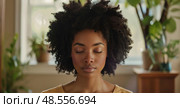 African American woman with her eyes closed is looking down. Her expression is introspective and contemplative. Стоковое AI-изображение, AI-художник Данила Большаков / Фотобанк Лори