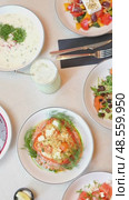 Traditional cuisine dishes are being placed on a table, creating a visually appealing arrangement of vibrant colors and textures. Стоковое видео, видеограф Данил Руденко / Фотобанк Лори