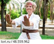 Mature lady in kimono exercising outdoors. Стоковое фото, фотограф Татьяна Яцевич / Фотобанк Лори