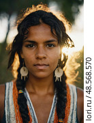This striking portrait features a young Aboriginal Australian woman with braided hair, adorned with traditional earrings, radiating strength amid a setting sun in nature Generative AI. Стоковое AI-изображение, AI-художник Юлия Петровская / Фотобанк Лори
