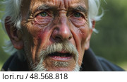 A close-up of an old man's face streaked with sadness and thoughtful as he listens to a lamentation song, the shadows of tree branches dancing across his face. Стоковое AI-видео, аниматор Sergey Grishin / Фотобанк Лори