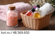 Essential oils and bath salts in a cozy spa setting with towels for relaxation and self-care. Стоковое AI-изображение, AI-художник Сергей Толмачёв / Фотобанк Лори