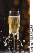 A glass of champagne captures the moment as bubbles rise, splashing joyfully against a backdrop of soft golden lights, evoking feelings of celebration and elegance. Стоковое AI-видео, аниматор Оксана Медведева / Фотобанк Лори