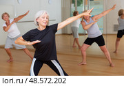 Smiling mature woman enjoying active dancing in dance studio. Стоковое фото, фотограф Яков Филимонов / Фотобанк Лори