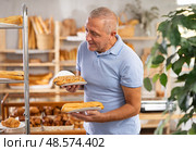 Elderly man with bocadillo sandwich in bakery. Стоковое фото, фотограф Яков Филимонов / Фотобанк Лори