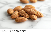 Nuts are arranged on a marble surface showcasing detailed textures. Орехи разложены на мраморной поверхности, демонстрирующей детальные текстуры. Стоковое AI-изображение, AI-художник Katsiaryna Repich / Фотобанк Лори