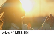 Young woman enjoying golden hour sunlight. Стоковое видео, видеограф Константин Шишкин / Фотобанк Лори