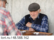 Пенсионеры с азартом играют в нарды. Активное долголетие. Редакционное фото, фотограф Evgenia Shevardina / Фотобанк Лори