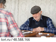 Пенсионеры с азартом играют в нарды. Активное долголетие. Редакционное фото, фотограф Evgenia Shevardina / Фотобанк Лори