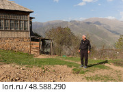 A man stands against the backdrop of mountains. View of the mountains in Armenia. Village in Tavush region. Редакционное фото, фотограф Evgenia Shevardina / Фотобанк Лори