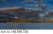 Beautiful lake landscape. Ripples on the surface of calm blue water. Green vegetation on the coastal hills. Picturesque clouds in the azure sky. The evening golden hour. Madagascar. Lake Mantasoa. Стоковое фото, фотограф Вера Ивановна Кубарева / Фотобанк Лори