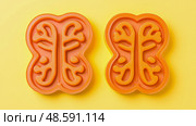 Orange Brain Teasers on Yellow: A pair of mind-bending brain-shaped puzzles, great for educational games and intellectual stimulation. Стоковое AI-изображение, AI-художник Данила Большаков / Фотобанк Лори