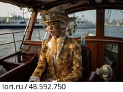 Golden Goddess Adrift: Captivating China Woman Exudes a Spellbinding Aura of Glamour as She Sits Confidently on a Boat in the Twilight. Стоковое AI-изображение, AI-художник Данила Большаков / Фотобанк Лори