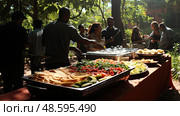 Outdoor buffet service with fresh ingredients, catered event meal. Стоковое AI-изображение, AI-художник Данила Большаков / Фотобанк Лори