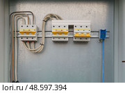 Крупный план автоматических выключателей с проводами внутри электрической панели для защиты электрической цепи от повреждения. Стоковое фото, фотограф Дарья Савченко / Фотобанк Лори