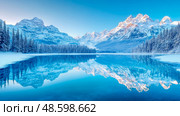 Winter wonderland landscape with mountains and lake reflection. Стоковое AI-изображение, AI-художник Данила Большаков / Фотобанк Лори