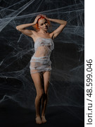 Red-haired woman entangled in a web trap creates an intriguing visual narrative. Стоковое фото, фотограф Гурьянов Андрей / Фотобанк Лори