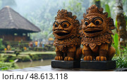 Two elaborately carved wooden guardian statues stand at the entrance of a traditional Balinese temple in Ubud, surrounded by lush greenery. Стоковое AI-изображение, AI-художник Данила Большаков / Фотобанк Лори