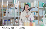 Woman scans the barcode of a package of pads on mobile, she looks at the information and the level of absorbency. Customer buys feminine hygiene products in a pharmacy using a qr code. Стоковое видео, видеограф Яков Филимонов / Фотобанк Лори