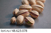 Closeup of pistachios rolling on textured surface in natural light. Стоковое AI-видео, аниматор Башкирова Анна / Фотобанк Лори