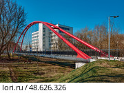 Cityscape, new red arched pedestrian bridge over the Yauza River: Moscow, Russia - April 16, 2025. Редакционное фото, фотограф Алексей Голованов / Фотобанк Лори