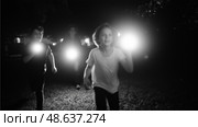 Kids exploring the night with flashlights in a backyard adventure during a late summer evening. Стоковое AI-изображение, AI-художник Сергей Толмачёв / Фотобанк Лори