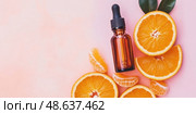 Amber dropper bottle next to orange slices. Citrus essential oil. Natural vitamin C serum and face cream, skin care products. Cosmetic and fresh fruit, bright trendy layout. Antioxidant Extract plant. Стоковое AI-изображение, AI-художник Марина Демидюк / Фотобанк Лори