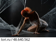 Red-haired woman entangled in a net trap surrounded by synthetic webbing. Стоковое фото, фотограф Гурьянов Андрей / Фотобанк Лори