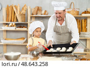 Daughter helps father baker to make pastries, lubricate croissants with loosened egg. Стоковое фото, фотограф Татьяна Яцевич / Фотобанк Лори