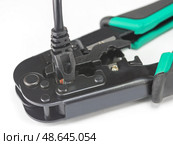 Черный LAN кабель и инструмент обжимки кабелей на белом фоне. LAN cable and cable crimping tool on white background. Стоковое фото, фотограф Татьяна Д / Фотобанк Лори